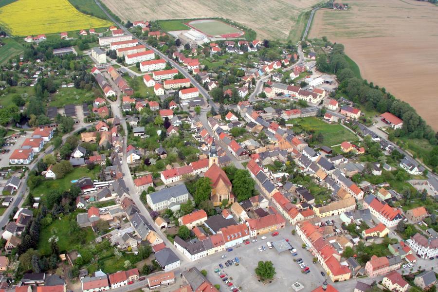 Luftbild mit Häusern, Straßen und Markt der Stadt Elstra