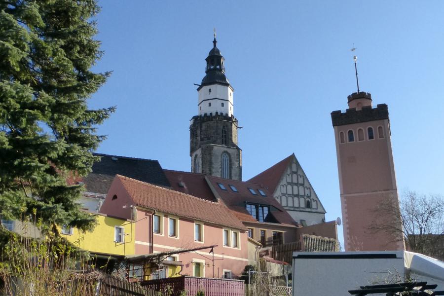 Häuser und ein Turm mit Kirche im Hintergrund