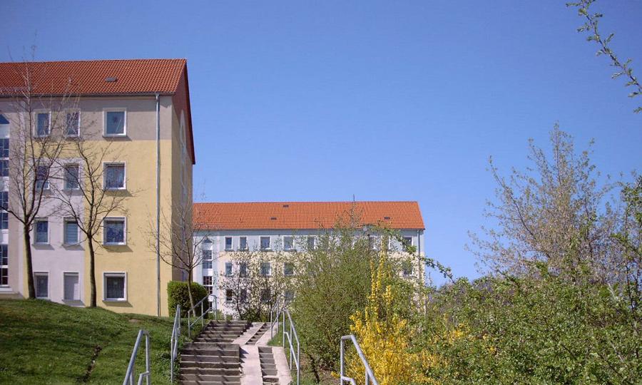 Zwei Wohnblöcke mit einer Treppe und Wiese im Vordergrund