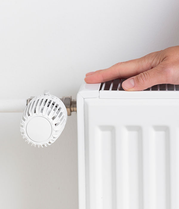 Hand liegt auf einer Heizung