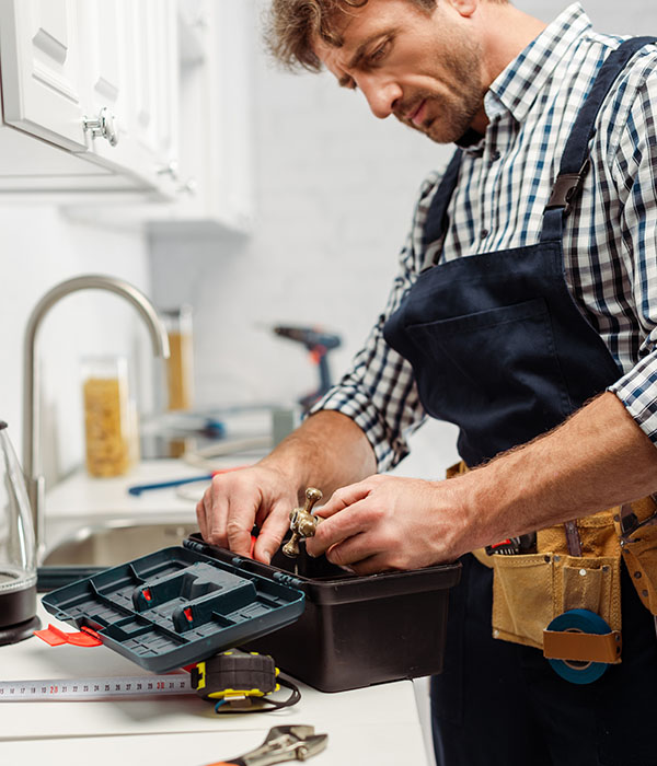 Handwerker sucht in Werkzeugkiste nach Werkzeug